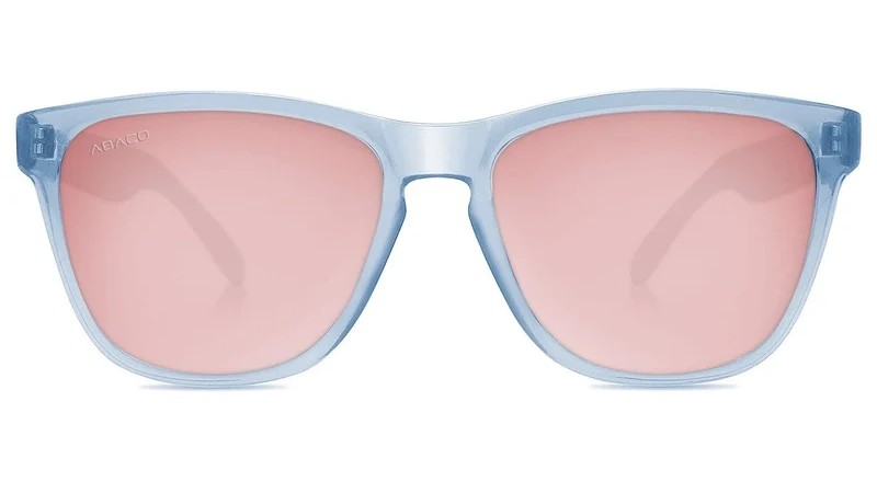 Studio product photograph of light blue translucent sunglasses with pink lenses, front view